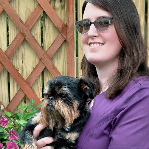 Kristin Brunnegraff holding a small black and tan dog.
