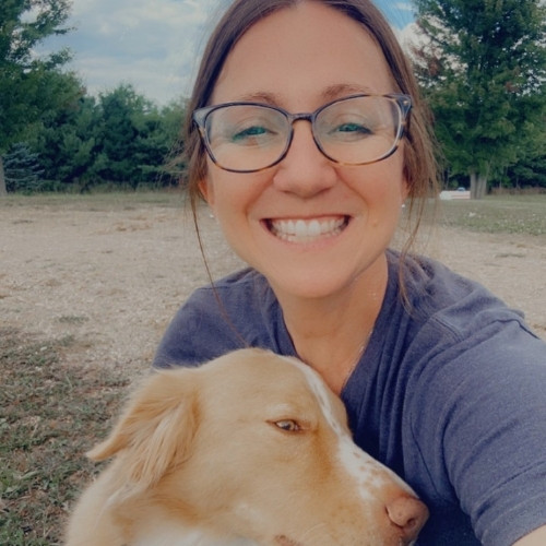 Mandy Holdsworth holding a light brown dog close.
